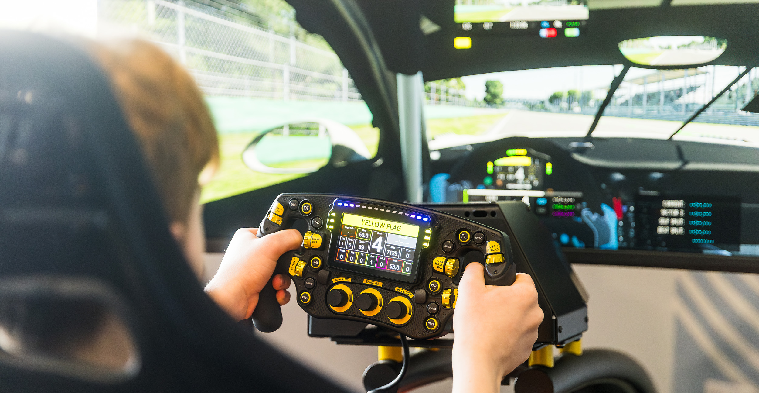 A driver at the wheel of a Buckmore Park racing simulator